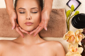 Portrait of beautiful young healthy woman relaxing and getting head massage in the spa salon.